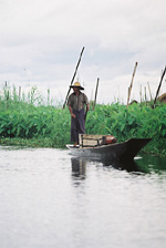 Kanoe z teakového dřeva a plovoucími zahradami v pozadí Kanoe z teakového dřeva a plovoucími zahradami v pozadí